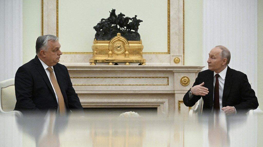 Buda Péter és Vladimir Putyin beszélget egy szalonban, háttérben aranyozott díszítés és szobor.